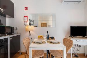 a small kitchen with a white table and chairs at Casa Viola in Faro +14 photos