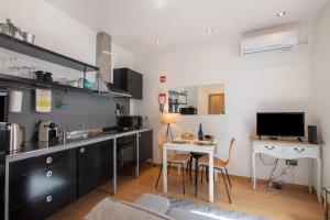 a kitchen with a sink and a table with a desk at Casa Viola in Faro