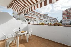 a white balcony with a white table and chairs at Sun and Calm Las Floritas in Playa de las Americas