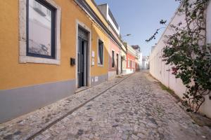 a cobblestone street in an alley between buildings at Casa Viola in Faro