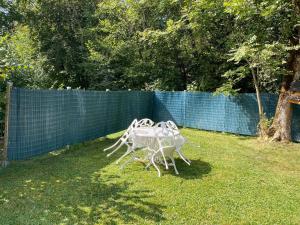 a white table and chairs sitting in the grass at Chalet 6p Confort - Le chevreuil in Verchaix +2 photos