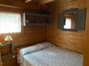 a bedroom with a bed in a wooden cabin at Chalet 6p Confort - Le chevreuil in Verchaix