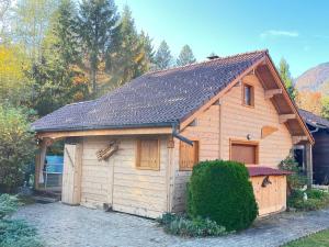 a wooden building with a garage in a yard at Chalet 6p Confort - Le chevreuil in Verchaix