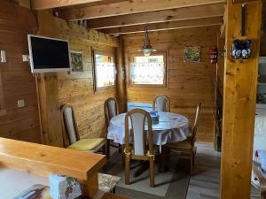 a dining room with a table and chairs in a cabin at Chalet 6p Confort - Le chevreuil in Verchaix