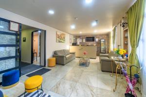 ein Wohnzimmer mit Sofas und Sesseln und eine Küche in der Unterkunft Hotel Boutique Las Campanas in Tlaxcala de Xicohténcatl