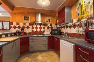 a large kitchen with red and white appliances at Tour Catalane in Ille-sur-Têt +24 photos