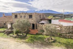 an old stone house with mountains in the background at Tour Catalane in Ille-sur-Têt