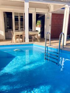 a large blue swimming pool in front of a house at Villa SELAH in Le Moule
