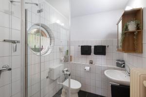 a white bathroom with a toilet and a sink at Ferienwohnung Waldblick in Remscheid +17 photos