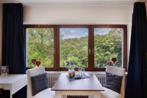 a dining room with a table and a large window at Ferienwohnung Waldblick in Remscheid