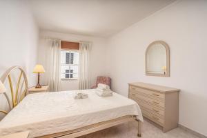 a bedroom with a bed and a dresser and a mirror at Maralvor 301 in Alvor +12 photos