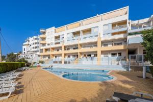 a building with a swimming pool in front of a building at Maralvor 301 in Alvor