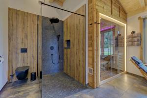 a bathroom with a shower with a glass door at Luxus-Chalet Mühlberg in Eppenschlag +27 photos