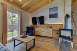 a living room with a tv and a couch and a table at Luxus-Chalet Mühlberg in Eppenschlag
