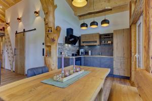 a kitchen with a wooden table and blue cabinets at Luxus-Chalet Mühlberg in Eppenschlag