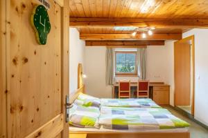 a bedroom with a bed in a room with wooden walls at Gasthaus Mamoosen in Penning
