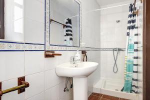 a white bathroom with a sink and a mirror at Silla Vieja Uno in Vejer de la Frontera +16 photos