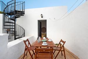 a wooden table and chairs on a balcony with stairs at Silla Vieja Uno in Vejer de la Frontera