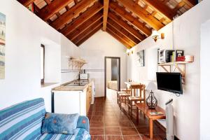 a kitchen and living room with wooden ceilings at Silla Vieja Uno in Vejer de la Frontera