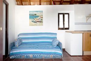 a couch in a room with a painting on the wall at Silla Vieja Uno in Vejer de la Frontera