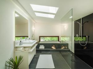 a bathroom with a tub and a sink and a shower at Chalet Wolfbachgut in Taxenbach +35 photos