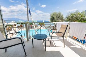 a balcony with chairs and a table and a swimming pool at Nikiana Sailing Beach Club in Nikiana