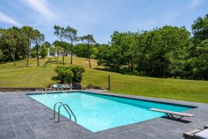 a swimming pool in a yard with a playground at Espace, Luxe, Calme Et Nature in Saint-Martin-de-Seignanx