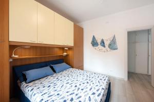 a bedroom with a bed with a blue comforter at Arenzano A Due passi dal mare in Arenzano