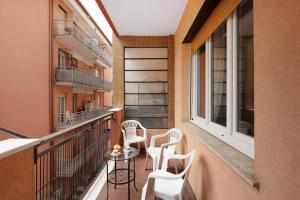 a balcony with white chairs and a table at Arenzano A Due passi dal mare in Arenzano
