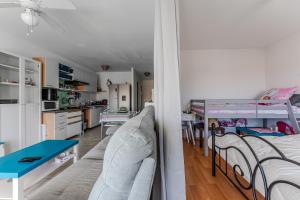 a living room with a couch and a bed and a table at Appartement proche plage Parentis in Parentis-en-Born
