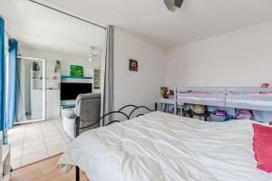 a bedroom with a bed and a living room at Appartement proche plage Parentis in Parentis-en-Born