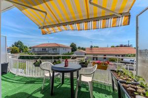 a patio with a table and chairs on a balcony at Appartement proche plage Parentis in Parentis-en-Born