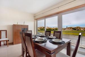 a dining room with a table and a large window at A O - Apartamento Gâmboa in Peniche