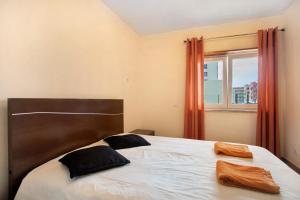 a bedroom with a bed with two pillows and a window at A O - Apartamento Gâmboa in Peniche