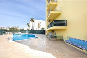a building with a swimming pool next to a building at Casa Cláudia - Cond do Mar in Lagos