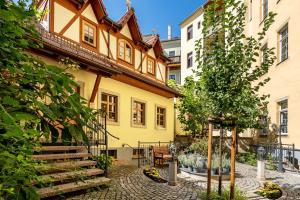 a courtyard of a building with stairs and a tree at Altstadtidyll Meißen in Meißen