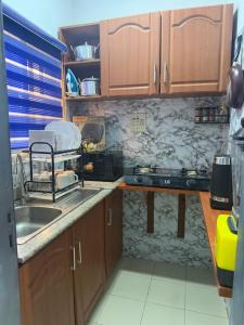 a kitchen with wooden cabinets and a sink at Max Court in Ikeja