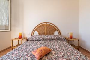 a bedroom with a bed with two candles and two tables at Casa Vacanze 21 Aprile - 1 in Calasetta