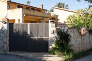 a black gate in front of a house at Casa Delle Pomelie in Trappeto