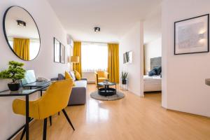 a living room with a table and yellow chairs at PrimeStayBudapest in Budapest