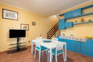 a kitchen with a table and chairs and a tv at Casa Delle Pomelie in Trappeto