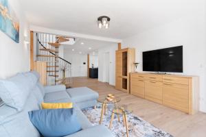 a living room with a blue couch and a tv at Fewo Bergfeld in Mosbach