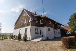 a large white house with a wooden roof at Fewo Bergfeld in Mosbach