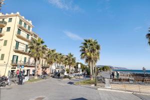 a street with palm trees in front of a building at Smart Home Loano in Loano