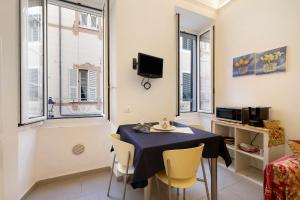 a dining room with a table and chairs and windows at Smart Home Loano in Loano