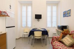 a kitchen and living room with a table and a couch at Smart Home Loano in Loano