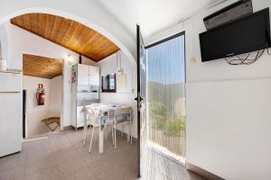 a kitchen and dining room with a table and a television at Abrigo do Pescador in Aljezur