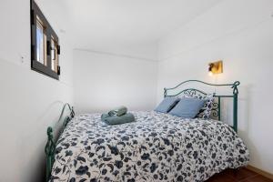 a bedroom with a bed with a black and white comforter at Abrigo do Pescador in Aljezur