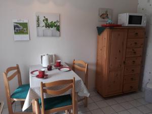 a kitchen with a table and chairs and a microwave at Ferienwohnung 'unter Der Linde' in Neuenkirchen