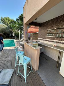 a blue chair sitting on a deck next to a pool at Maison ROMIA in Fréjus